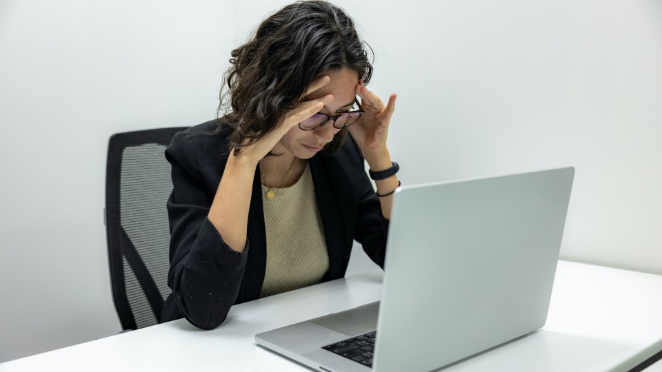 Frau sitzt angestrengt vor Laptop